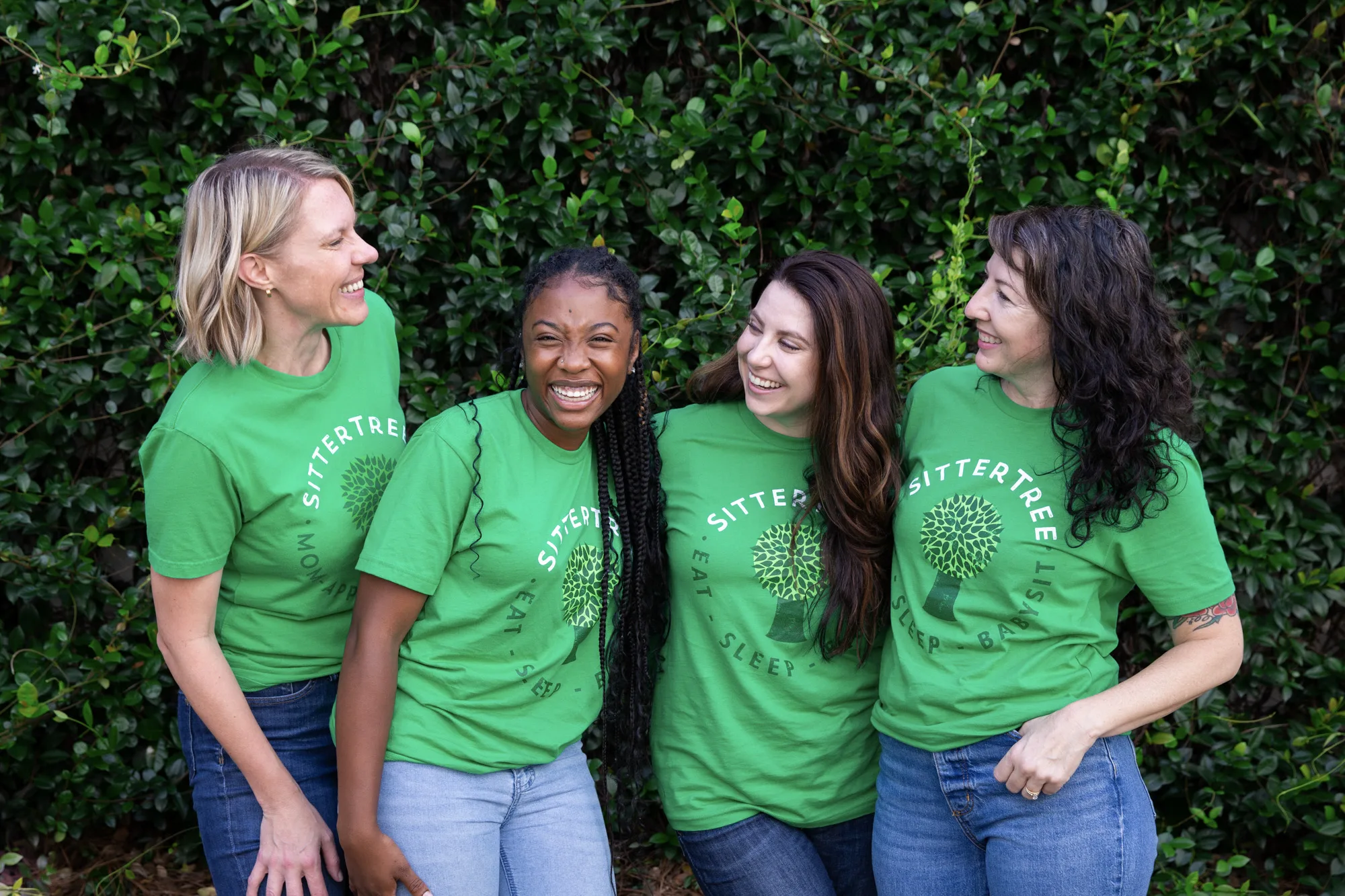 The Best Babysitter Apps and Websites to Hire a Babysitter The Best Babysitter Apps and Websites to Hire a Babysitter: Four smiling women wearing green SitterTree t-shirts standing outdoors in front of lush greenery, enjoying a lighthearted moment together